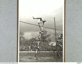 NEW GUINEA. 1943-11-20. QX23067 PRIVATE T. J. HOGAN CLEARING THE BAR IN THE POLE VAULT AT THE CHAMPIONSHIP SPORTS MEETING ORGANISED BY THE 18TH AUSTRALIAN INFANTRY BRIGADE TO CELEBRATE THE FOURTH ..