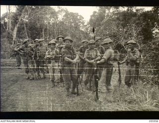 Donadabu, New Guinea. 1943-07-26. Members of 7 Platoon, A Company, 61st Battalion, waiting for the start of a supply dropping exercise conducted by the 7th Australian Infantry Brigade. Left to ..