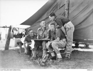 BUT, NEW GUINEA. 1945-04-10. 2/8 INFANTRY BATTALION OFFICERS OUTSIDE A TENT AT THEIR CAMP. IDENTIFIED PERSONNEL ARE:- LT F.G. CHAFFE, STAFF OFFICER (1); MAJ C.L. SIMPSON, ADMINISTRATIVE COMMANDER ..