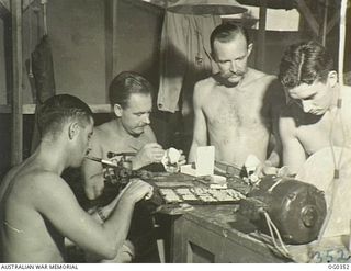 NEW GUINEA. C. 1944-05. RAAF DENTAL TECHNICIANS WORKING ON DENTURES IN THE WORKSHOP AT A DENTAL SECTION