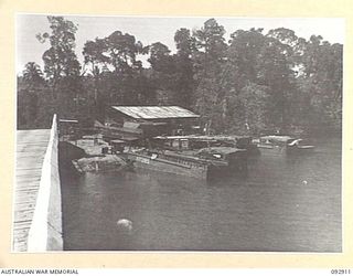 JACQUINOT BAY, NEW BRITAIN. 1945-06-11. LOOKING DOWN ON THE BRIDGE REPAIR SLIPWAYS AT THE MOUTH OF THE KALUMALAGI RIVER, IN 5 BASE SUB-AREA. THE BRIDGE IS ARCHED TO ALLOW TRAFFIC THROUGH TO SLIPS