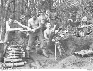 SHAGGY RIDGE, NEW GUINEA. 1943-12-27. MEMBERS OF A 3 INCH MORTAR CREW OF THE 2/16TH AUSTRALIAN INFANTRY BATTALION, 21ST AUSTRALIAN INFANTRY BRIGADE IN ACTION BOMBARDING THE "PIMPLE" PRIOR TO THE ..