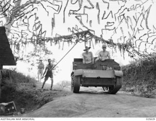 PORT MORESBY, PAPUA. 1942-07. AN AUSTRALIAN BREN GUN CARRIER IN NEW GUINEA RETURNING FROM A PATROL, IS TAKEN INTO A WELL CONCEALED POSITION UNDER CAMOUFLAGE NETTING, TO PREVENT OBSERVATION FROM ..