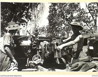 BOUGAINVILLE ISLAND, 1944-11-17. STAFF SERGEANT W. COSSTICK (1) AND VX83213 CRAFTSMAN C.H. EVANS (2) 4TH FIELD REGIMENT, CARRYING OUT MAINTENANCE ON A 25 POUNDER GUN