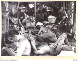 TOROKINA, BOUGAINVILLE. 1945-09-23. JAPANESE NAVAL TROOPS WHO CRACKED UP ON THE 10-MILE MARCH FROM THE BUKA AREA, RECEIVING MEDICAL ATTENTION FROM MEDICAL ORDERLIES OF 27 INFANTRY BATTALION, IN A ..