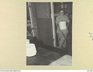 LAE, NEW GUINEA. 1945-05-07. PRIVATE N.J. TEAGUE, CARRYING PLATES BACK TO THE KITCHEN FOR THE FIRST WASHING UP IN THEIR NEW QUARTERS AT THE AUSTRALIAN WOMEN'S ARMY SERVICE BARRACKS, BUTIBUM ROAD. ..