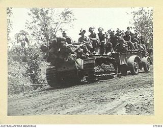 BOUGAINVILLE ISLAND. 1945-02-27. A TRACTOR AND TRAILER LOADED WITH TROOPS OF THE 9TH INFANTRY BATTALION MOVING ACROSS A BAILEY BRIDGE AS MAWARAKA ON THE MOSIGETTA ROAD WHILE ON THEIR WAY TO ..