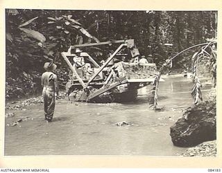 BOUGAINVILLE, SOLOMON ISLANDS. 1944-12-08. LANCE CORPORAL T.J. WEBSTER, (1), WORKING WITH 5 AND 11 FIELD COMPANY, ROYAL AUSTRALIAN ENGINEERS, TROOPS ATTEMPTING TO PULL A BOGGED BULLDOZER WINCHED TO ..