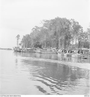 JACQUINOT BAY, NEW BRITAIN. 1945-04-12. FLOATING WORKSHOPS BUILT INTO LANDING CRAFT MECHANIZED BARGES STAND BY READY TO REPAIR OR TOW IN ANY DAMAGED BARGES ON THE RUN TO WIDE BAY FROM JACQUINOT ..