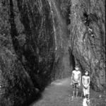 Children standing before waterfall