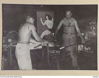 JACQUINOT BAY, NEW BRITAIN. 1945-04-12. CORPORAL L.L. LAVISKI (1), AND SERGEANT R.W. PIKE (2), AT WORK IN THE BLACKSMITH'S SHOP, 3016 ENGINEER BOAT MAINTENANCE COMPANY (US ARMY), ATTACHED 5 ..