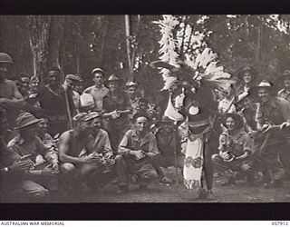 DOBODURA, NEW GUINEA. 1943-10-10. WITH ALLIED TROOPS BEATING TIME FOR HIM, SENGARA, A NATIVE FROM HANNAHUMBUDI VILLAGE, DOES A NATIVE DANCE