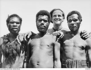 RAMU VALLEY, NEW GUINEA, 1943-10-03. NX171438 SERGEANT B.M. L'ESTRANGE MM OF THE 2/7TH AUSTRALIAN INDEPENDENT COMPANY, WITH THREE CHIMBU NATIVE CARRIERS