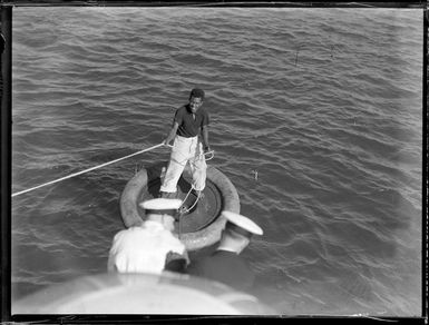 Fijian man on a float holds on to rope attached to the seaplane Aotearoa in Suva