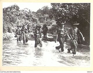 WONGINARA MISSION, NEW GUINEA. 1945-04-04. TIRED B COMPANY, 2/3 INFANTRY BATTALION TROOPS MOVE BACK TO COMPANY HEADQUARTERS FOR A RESPITE FROM FIGHTING IN THICK JUNGLE IN THE TORRICELLI MOUNTAINS, ..