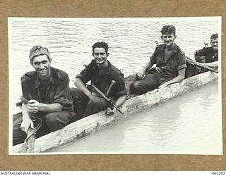 RAMU RIVER FAITA AREA, NEW GUINEA. 1944-01-07. MEMBERS OF A PATROL OF THE 2/2ND COMMANDO SQUADRON BEING FERRIED BACK TO CAMP IN A NATIVE DUGOUT CANOE AFTER A PATROL THROUGH JAPANESE HELD TERRITORY ..