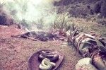 Stones are heated for an earth oven, in which various foods, including snakes (seen in foreground), will be cooked, wrapped in banana leaves