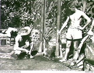 THE SOLOMON ISLANDS, 1945-02-26. TWO AUSTRALIAN SERVICEMEN WASHING CLOTHES AT THEIR CAMPSITE ON BOUGAINVILLE ISLAND. (RNZAF OFFICIAL PHOTOGRAPH.)