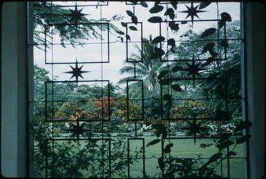 Bomana Cemetery, through a wrought iron window (towards the right) : Port Moresby, Papua New Guinea, 1953 / Terence and Margaret Spencer