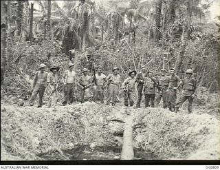 MOMOTE, LOS NEGROS ISLAND, ADMIRALTY ISLANDS. 1944-03-18. RAAF GUARDS AND AMERICAN TROOPS PATROLLING TRACKS NEAR MOMOTE AIRFIELD MEET AT A BOMB CRATER. RAAF KITTYHAWK AIRCRAFT WERE OPERATING FROM ..