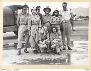 LAE AIRSTRIP, NEW GUINEA. 1945-09-25. MEMBERS OF THE DARYA COLLIN BALLET TROUPE WITH OFFICERS AFTER THEIR ARRIVAL BY RAAF AIRCRAFT. THE TROUPE HAS BEEN TOURING THE ISLANDS GIVING AN AVERAGE OF TWO ..