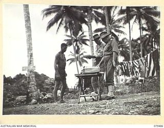 JACQUINOT BAY, NEW BRITAIN. 1945-03-11. NX12229 LIEUTENANT-COLONEL H.T. ALLAN, OBE, MC, COMMANDING OFFICER, 5TH BASE SUB AREA (3) PRESENTING A TROPHY TO PRIVATE GILBERT (1) AT THE CONCLUSION OF THE ..