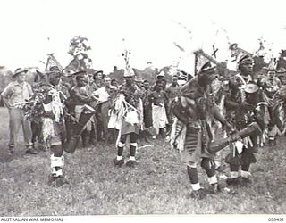 LAE, NEW GUINEA, 1945-12-25. A DANCE IN PROGRESS AT THE NATIVE SING-SING HELD AT THE MALAHANG NATIVE LABOUR COMPOUND TO CELEBRATE CHRISTMAS. MANY ALLIED AND AUSTRALIAN NEW GUINEA ADMINISTRATIVE ..