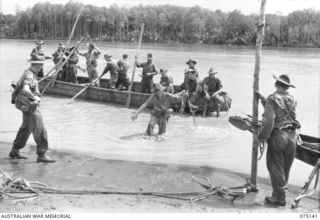 HANSA BAY-BOGIA HARBOUR, NEW GUINEA. 1944-08-09. TROOPS OF NO. 13 PLATOON, C COMPANY, 30TH INFANTRY BATTALION USING A CAPTURED JAPANESE BOAT TO CROSS THE MOUTH OF THE RAMU RIVER WHILE ON THEIR WAY ..