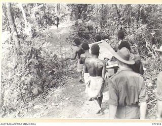 TOROKINA AREA, BOUGAINVILLE ISLAND. 1944-11-29. NATIVES EVACUATING N201130 PRIVATE K. MARTIN, A BATTLE CASUALTY IN THE ATTACK BY D COMPANY, 9TH INFANTRY BATTALION ON LITTLE GEORGE HILL. PRIVATE ..