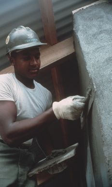 Builder 3rd Class (BU3) Marvin Chandler, a member of Naval Mobile Construction Battalion 62, applies stucco to the Central Kindergarten School near Port Vila. Seabees are helping to rapair damage caused by Cyclone Uma