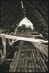 Canoes: small fishing canoe stacked on a large kula canoe in canoe-house shelter on the eastern coast of Kiriwina