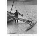 Man holding tiller for a boat, probably on Rongelap Atoll, summer 1964