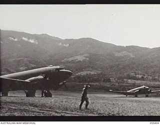 WAU, NEW GUINEA. 1943-08-08. DOUGLAS C47 DAKOTA AIRCRAFT LANDING ON THE AIRFIELD