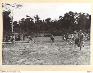 TOROKINA, BOUGAINVILLE, 1945-07-15. THE 3-LEGGED RACE IN PROGRESS DURING THE COMBINED ALLIED SPORTS CHAMPIONSHIP MEETING AT GLOUCESTER OVAL ARRANGED BY AUSTRALIAN ARMY AMENITIES SERVICE, ATTACHED 4 ..