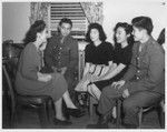 These Nisei soldiers and girls are being made at home by a hostess at the Nyack, N.Y., USO at a