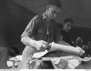 DUMPU, RAMU VALLEY, NEW GUINEA, 1944-02-10. VX139888 PRIVATE H.R. PELL (1) THE HEADQUARTERS COMPANY COOK, WITH VX142142 PRIVATE J.A. SHIELD (2) MAKING PIES FOR TROOPS OF HEADQUARTERS COMPANY, ..