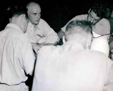 Photograph of Captain Charles B. McVay Talking to Correspondents After the Sinking of the USS Indianapolis (CA-35) at Guam