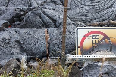 No Litter' sign burned by lava from the 2014 Kilauea Volcano eruption Pupu &lsquoō lava flow near Pahoa, Hawaii.