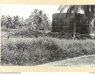 MILNE BAY, PAPUA, NEW GUINEA. 1944-04-03. A 500,000 GALLON OIL TANK IN A COCONUT PLANTATION AT THE 2ND BULK PETROLEUM STORAGE COMPANY. OTHER STORAGE TANKS CAN BE SEEN IN THE BACKGROUND