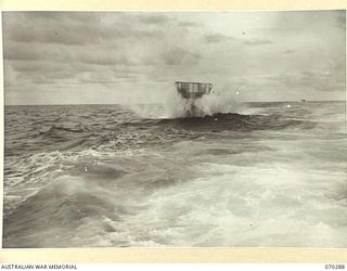 KELANOA AND BUTUBUTU, NEW GUINEA, 1944-02-08. A BARGE LOADED WITH TROOPS AND STORES OF HEADQUARTERS 5TYH DIVISION SIGNALS, IN A ROUGH SEA BETWEEN KELANOA AND BUTUBUTU