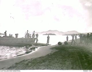 THE SOLOMON ISLANDS, 1945-05. SUPPLIES FOR AN AUSTRALIAN ARMY UNIT BEING OFF-LOADED FROM A LANDING CRAFT AT A NORTH BOUGAINVILLE BEACH. (RNZAF OFFICIAL PHOTOGRAPH.)