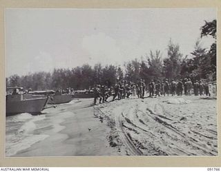 SORAKEN AREA, BOUGAINVILLE, 1945-05-06. TROOPS OF 26 INFANTRY BATTALION (A.I.F.) COMING OFF THE BARGE AT NO.1 BEACH AFTER A TRIAL LANDING, DURING PREPARATIONS FOR A LANDING AT THE NORTH END OF THE ..
