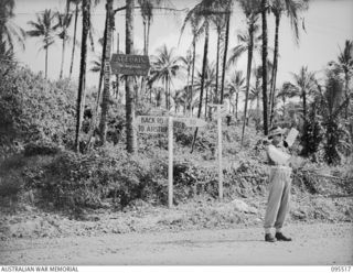 PALMALMAL, JACQUINOT BAY, NEW BRITAIN, 1945-08-24. A MILITARY POLICEMAN ON DUTY AT THE INTERSECTION OF DOCKS ROAD AND BACK ROAD DIRECTING 55 FIELD PARK COMPANY ROYAL AUSTRALIAN ENGINEERS TRAFFIC IN ..