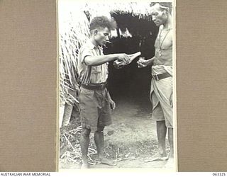 DUMPU, NEW GUINEA. 1944-01-04. MAKU A PAPUAN "DOCTOR BOY" GIVING MEDICINE TO A SICK MARKHAM VALLEY MAN AT THE AUSTRALIAN AND NEW GUINEA ADMINISTRATION UNIT NATIVE LABOUR HOSPITAL