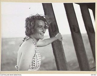 LAE, NEW GUINEA, 1945-05-18. SIGNALWOMAN B. DURWARD, AUSTRALIAN WOMEN'S ARMY SERVICE BARRACKS, STANDING IN THE WRECK OF A JAPANESE SHIP ON MALAHANG BEACH DURING A TOUR OF THE AREA CONDUCTED BY ARMY ..