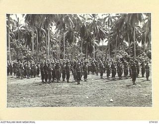 SIAR, NEW GUINEA. 1944-06-22. PERSONNEL OF HEADQUARTERS COMPANY, 57/60TH INFANTRY BATTALION STANDING TO ATTENTION DURING THE MORNING PARADE