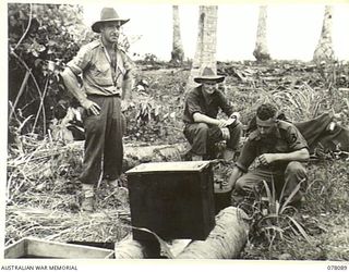 SUAIN PLANTATION, NEW GUINEA. 1944-12-15. GEORGE LOCK (3) AN ORIGINAL MEMBER OF THE BATTALION, PREPARING A MEAL FOR THE TROOPS OF THE 2/4TH INFANTRY BATTALION. ALSO IDENTIFIED IS PRIVATE E S DAWE ..