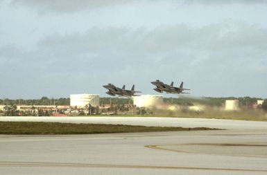 A pair of F-15 Eagle fighters take off in formation from Andersen Air Force Base (AFB), Guam, in support of Exercise COPE NORTH 2002