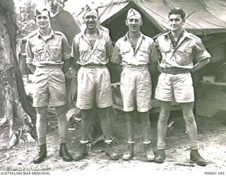 THE SOLOMON ISLANDS, 1945-01-12. FOUR NEW ZEALAND SERVICEMEN AT THEIR CAMPSITE. (RNZAF OFFICIAL PHOTOGRAPH.)