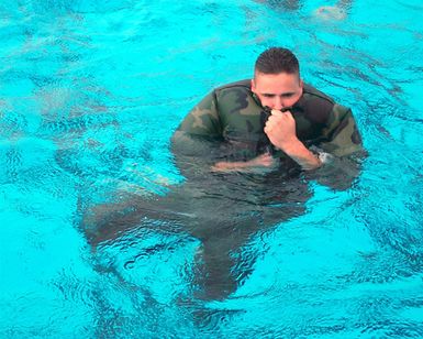 Private First Class (PFC) Chad Thomas, USMC, Head Quarters Battalion, Marine Corp Base Hawaii, Kaneohe Bay executes a blouse inflation maneuver while participating in swim qualification at the base swimming pool